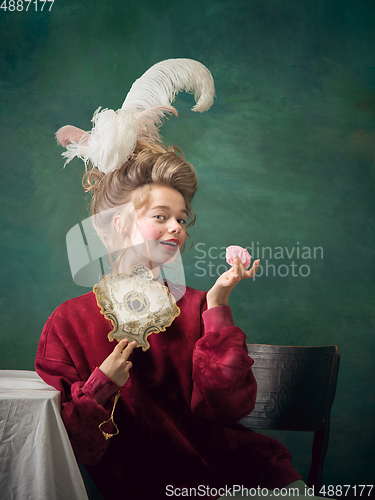 Image of Young woman as Marie Antoinette on dark background. Retro style, comparison of eras concept.