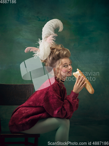 Image of Young woman as Marie Antoinette on dark background. Retro style, comparison of eras concept.