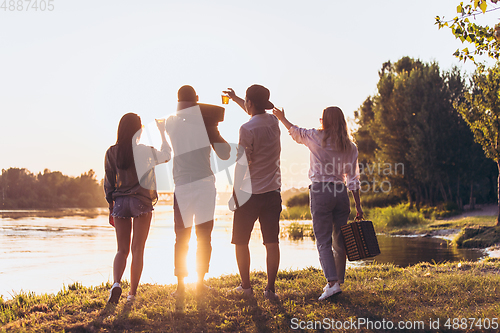 Image of Group of friends walking down during picnic at the beach. Lifestyle, friendship, having fun, weekend and resting concept.