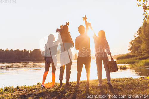 Image of Group of friends walking down during picnic at the beach. Lifestyle, friendship, having fun, weekend and resting concept.