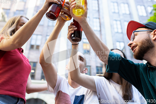 Image of Group of friends taking a stroll on city\'s street in summer day