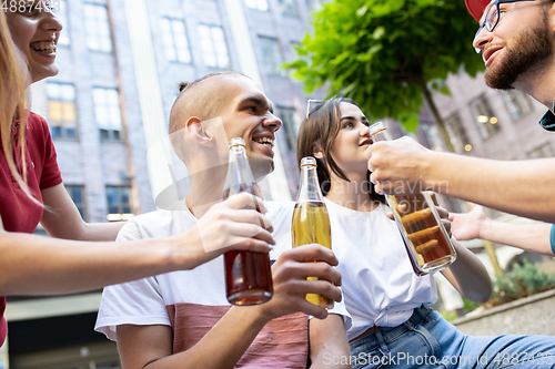 Image of Group of friends taking a stroll on city\'s street in summer day