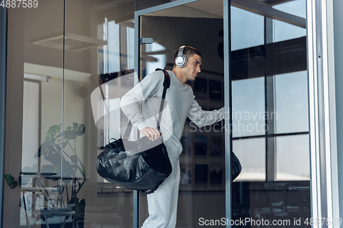 Image of Sports man against modern glassed building, airport in megapolis