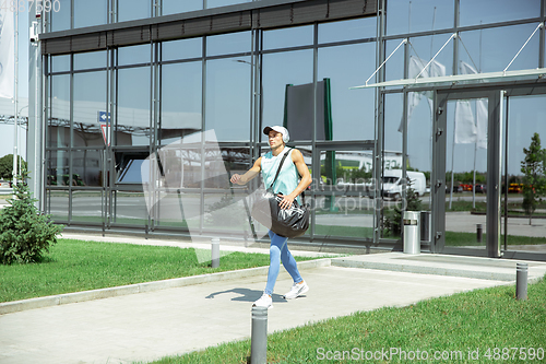 Image of Sports man against modern glassed building, airport in megapolis