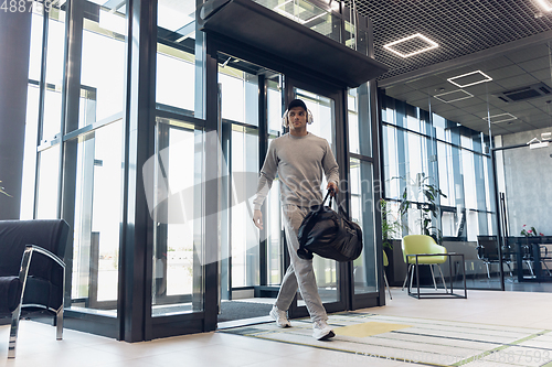 Image of Sports man against modern glassed building, airport in megapolis
