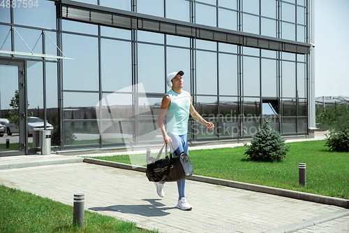 Image of Sports man against modern glassed building, airport in megapolis
