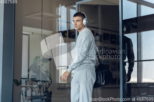 Image of Sports man against modern glassed building, airport in megapolis