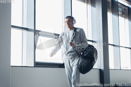 Image of Sports man against modern glassed building, airport in megapolis