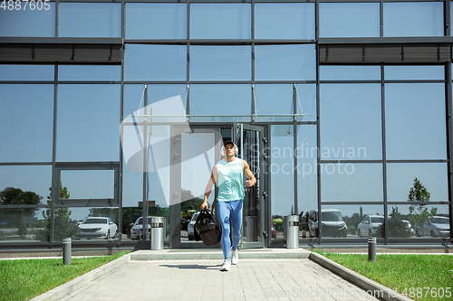 Image of Sports man against modern glassed building, airport in megapolis