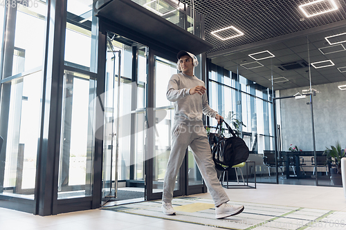 Image of Sports man against modern glassed building, airport in megapolis