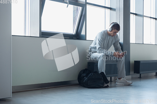 Image of Sports man against modern glassed building, airport in megapolis