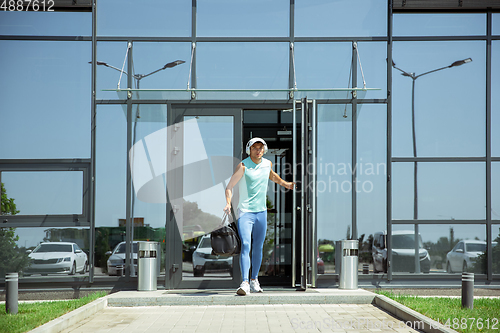 Image of Sports man against modern glassed building, airport in megapolis