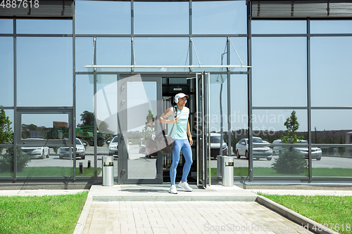 Image of Sports man against modern glassed building, airport in megapolis