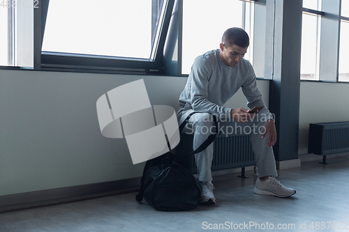 Image of Sports man against modern glassed building, airport in megapolis