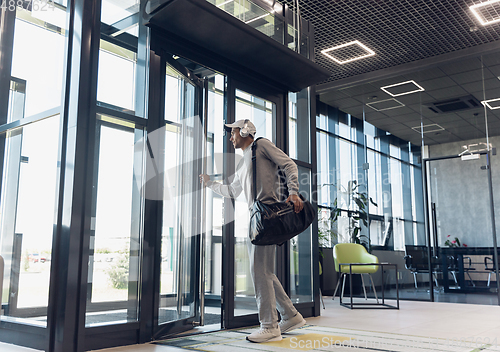 Image of Sports man against modern glassed building, airport in megapolis