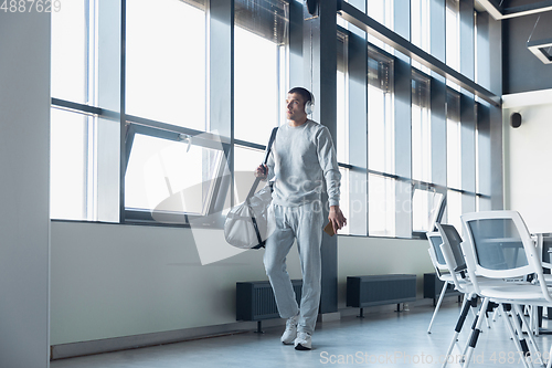 Image of Sports man against modern glassed building, airport in megapolis