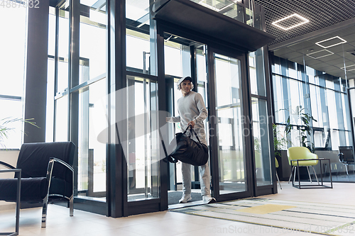 Image of Sports man against modern glassed building, airport in megapolis