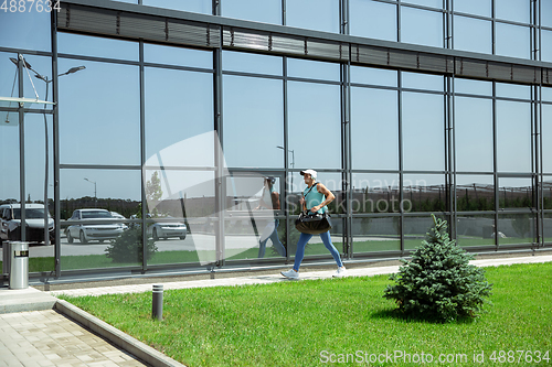 Image of Sports man against modern glassed building, airport in megapolis