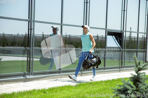 Image of Sports man against modern glassed building, airport in megapolis