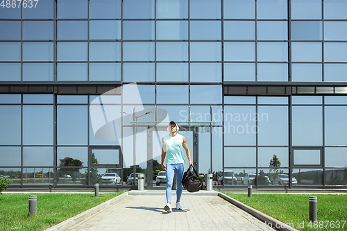 Image of Sports man against modern glassed building, airport in megapolis