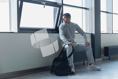 Image of Sports man against modern glassed building, airport in megapolis