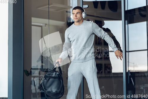 Image of Sports man against modern glassed building, airport in megapolis