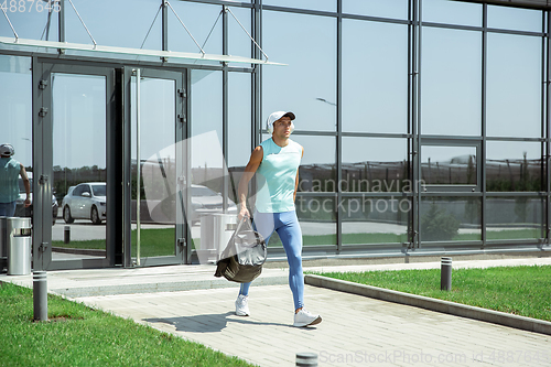 Image of Sports man against modern glassed building, airport in megapolis