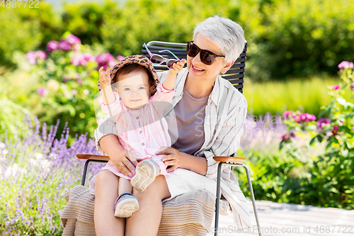 Image of happy grandmother and baby granddaughter at garden