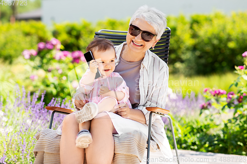 Image of grandmother and baby granddaughter with smartphone