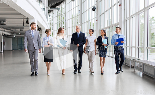 Image of business people walking along office building