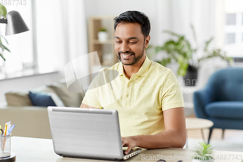 Image of indian man with laptop working at home office