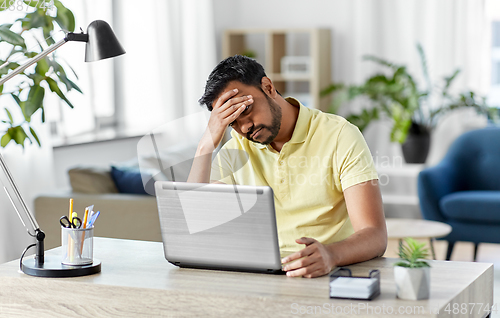 Image of indian man with laptop working at home office