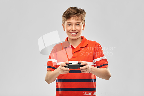 Image of smiling boy with gamepad playing video game