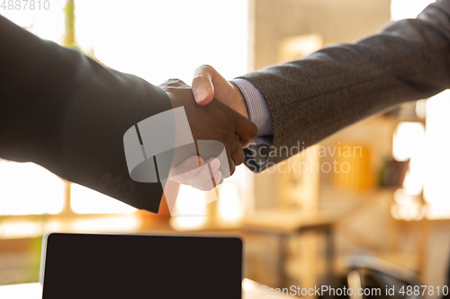 Image of Close up of businessmen shaking hands in conference room