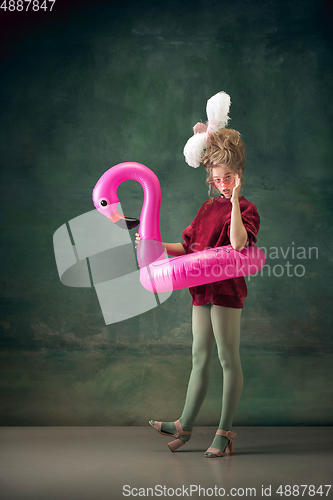 Image of Young woman as Marie Antoinette on dark background. Retro style, comparison of eras concept.