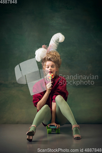 Image of Young woman as Marie Antoinette on dark background. Retro style, comparison of eras concept.