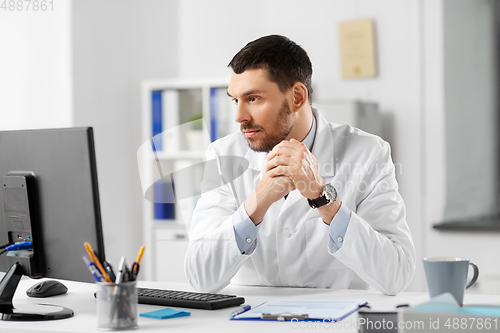Image of doctor with clipboard and computer at hospital