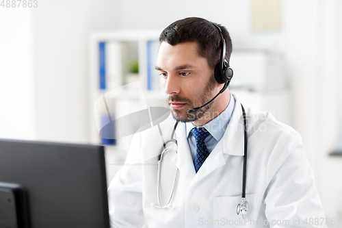 Image of male doctor with computer and headset at hospital