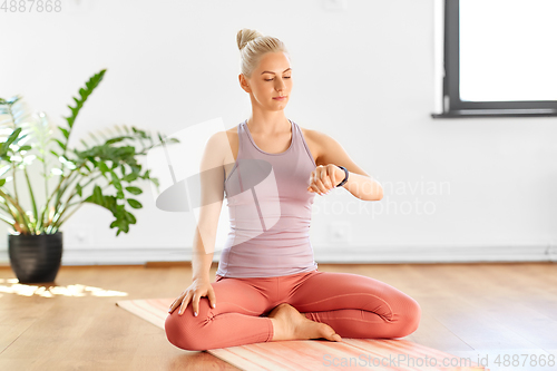 Image of woman with fitness tracker home or yoga studio