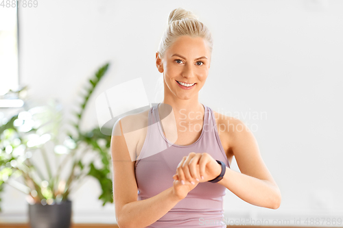 Image of woman with fitness tracker home or yoga studio