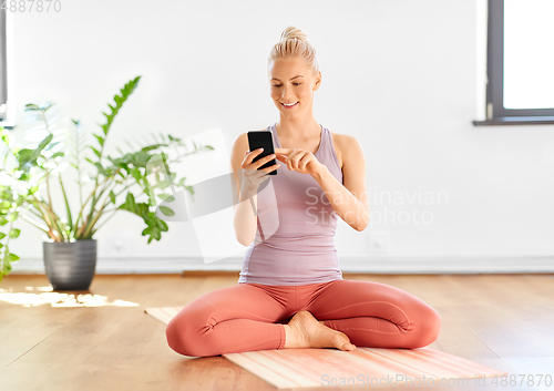 Image of woman with smartphone at home or yoga studio