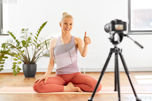 Image of woman with camera streaming for yoga blog at home