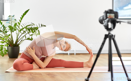 Image of woman with camera streaming for yoga blog at home