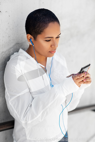 Image of african american woman with earphones and phone