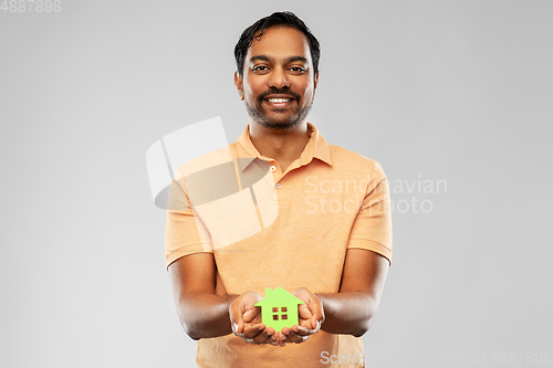 Image of smiling indian man holding green house icon