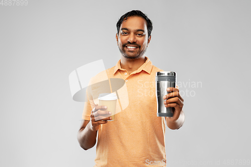 Image of man comparing thermo cup or tumbler and coffee cup