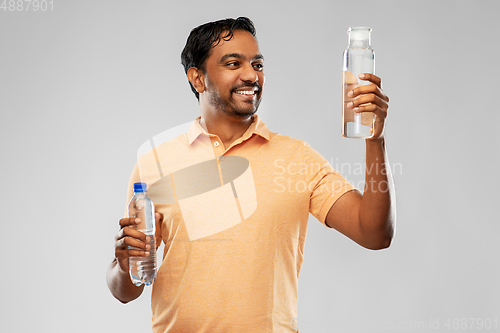 Image of indian man comparing water in different bottles