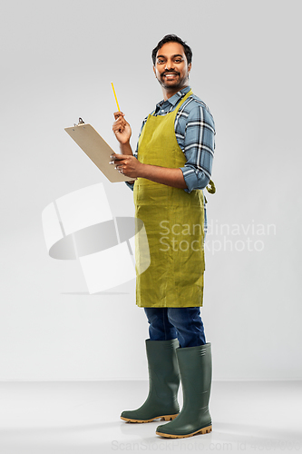 Image of happy indian gardener or farmer with clipboard