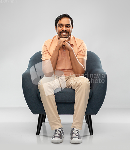 Image of happy smiling young indian man sitting in chair