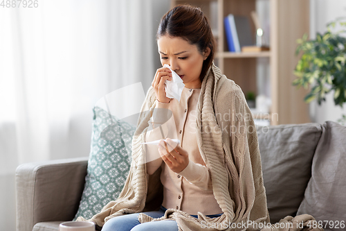 Image of sick woman measuring temperature by thermometer